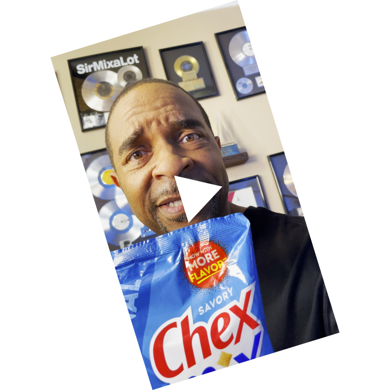 Sir Mix-A-Lot holding a bag of Chex Mix in Traditional flavor